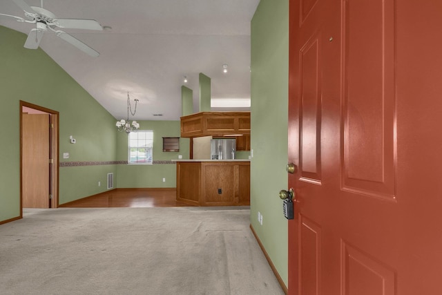 interior space featuring high vaulted ceiling, ceiling fan with notable chandelier, light colored carpet, baseboards, and visible vents