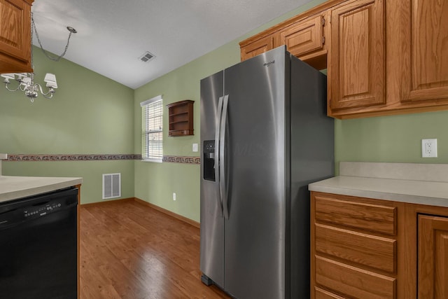 kitchen featuring black dishwasher, lofted ceiling, visible vents, and stainless steel refrigerator with ice dispenser