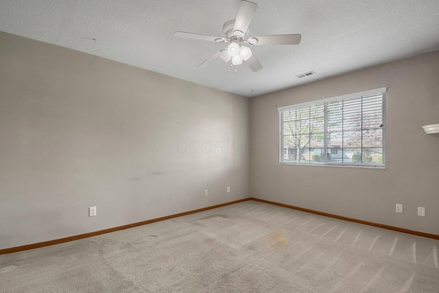 spare room featuring ceiling fan, light carpet, visible vents, and baseboards