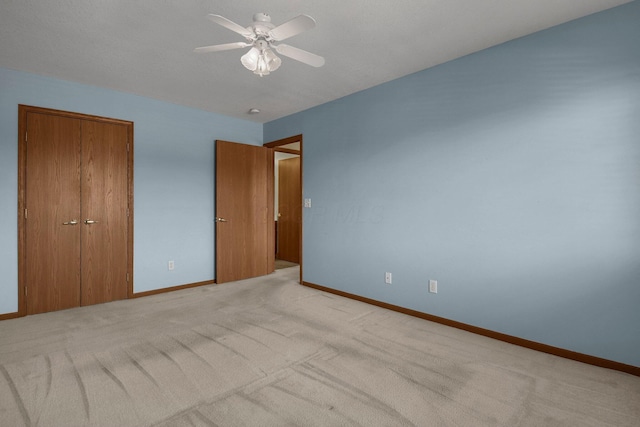 unfurnished bedroom featuring light carpet, baseboards, a closet, and ceiling fan