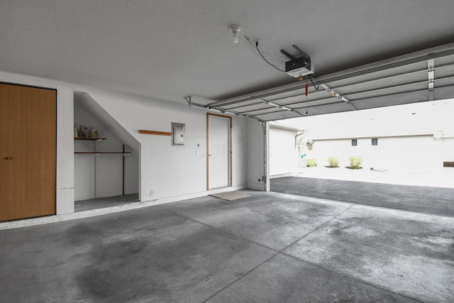 garage featuring electric panel and a garage door opener