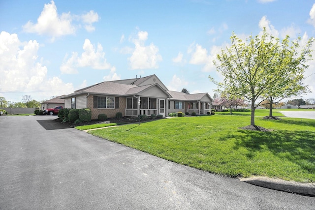 ranch-style home featuring a front lawn and brick siding