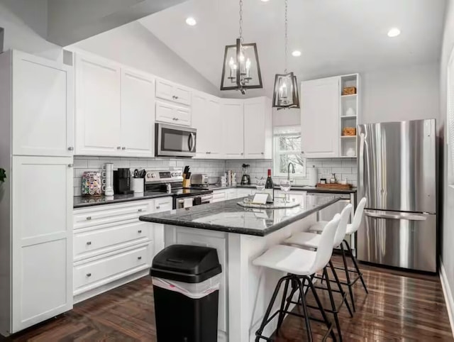 85 Dana Ave, Columbus, OH 43222 - kitchen with white cabinets, backsplash, appliances with stainless steel finishes, and a breakfast bar
