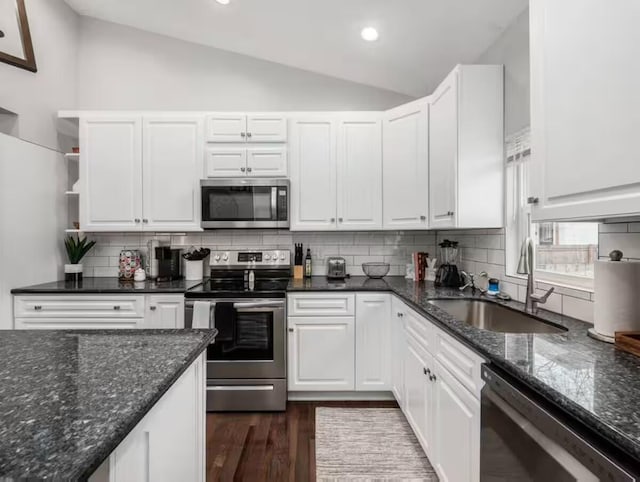 85 Dana Ave, Columbus, OH 43222 - kitchen featuring white cabinets, dark wood-style floors, a sink, vaulted ceiling, and appliances with stainless steel finishes