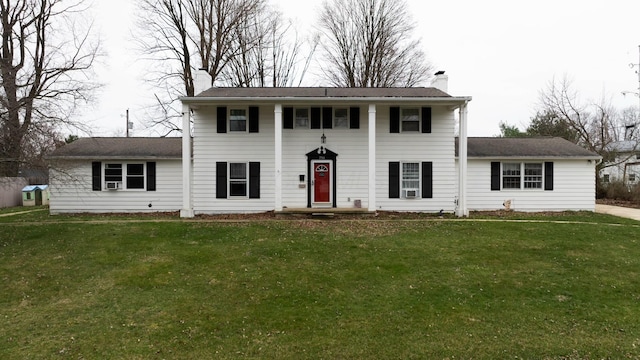 view of front facade featuring a front lawn and a chimney