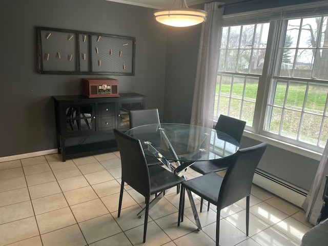 dining room featuring a baseboard radiator, baseboards, and light tile patterned floors