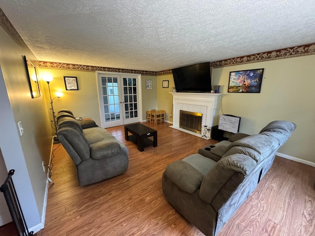 751 Vicksburg Dr, Mansfield, OH 44904 - living room with a textured ceiling, wood finished floors, baseboards, and a fireplace with flush hearth