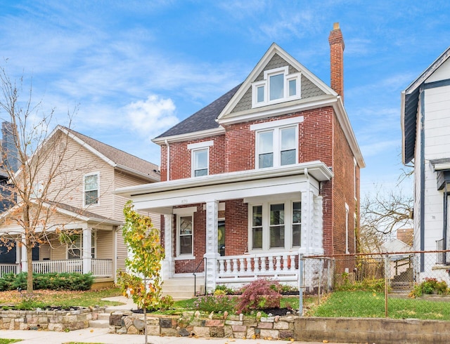 870 Oakwood Ave, Columbus, OH 43206 - view of front of house with brick siding, a chimney, covered porch, and fence