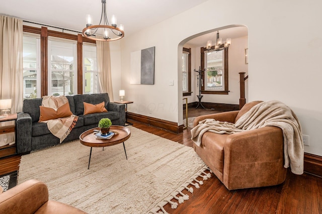 870 Oakwood Ave, Columbus, OH 43206 - living area featuring arched walkways, dark wood-style flooring, a chandelier, and plenty of natural light