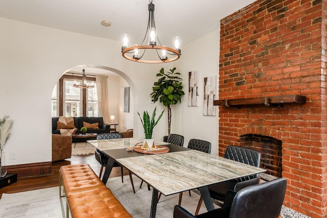 870 Oakwood Ave, Columbus, OH 43206 - dining area with arched walkways, a notable chandelier, wood finished floors, and baseboards