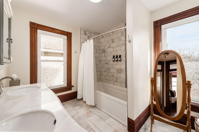 870 Oakwood Ave, Columbus, OH 43206 - bathroom featuring double vanity, shower / bath combo with shower curtain, baseboards, and a sink