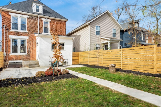 870 Oakwood Ave, Columbus, OH 43206 - rear view of property featuring a shingled roof, fence, a yard, entry steps, and brick siding
