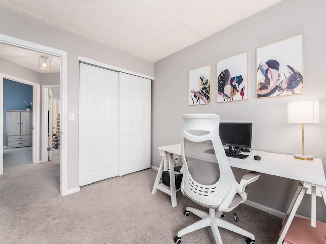 office area featuring a textured ceiling, baseboards, and carpet floors