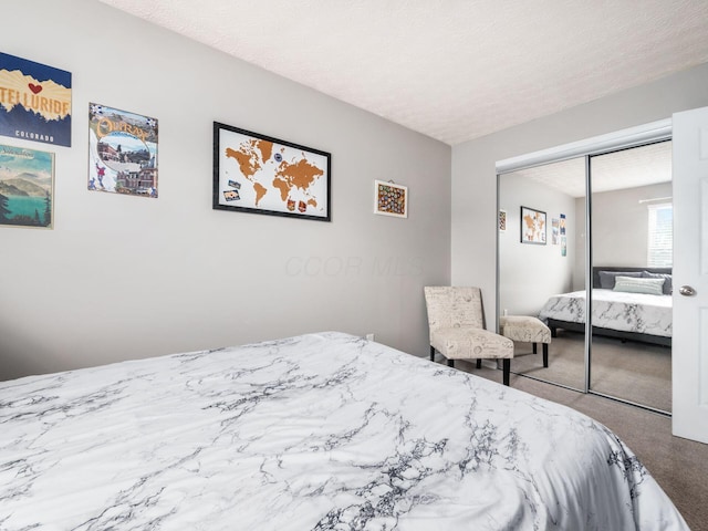 carpeted bedroom with a closet and a textured ceiling