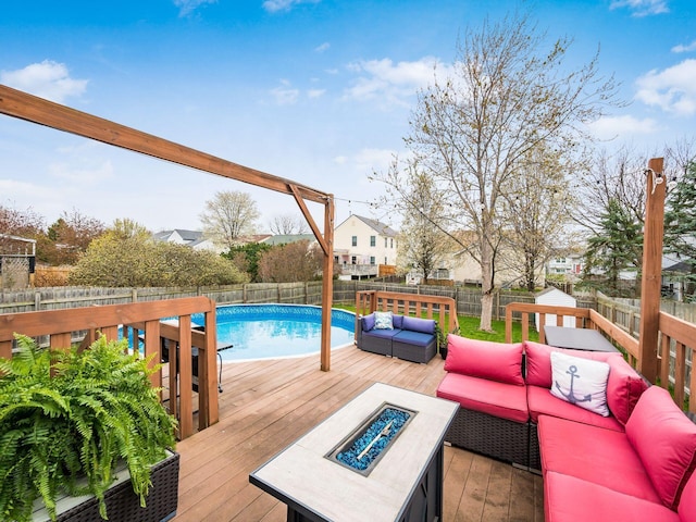wooden deck with an outdoor living space with a fire pit, a fenced backyard, and a fenced in pool