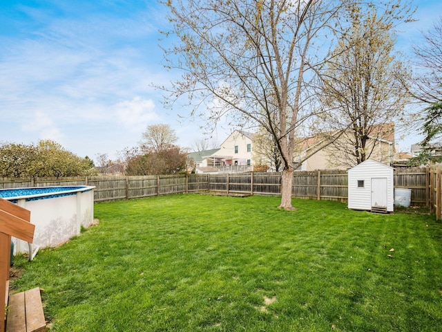view of yard featuring an outbuilding, a fenced backyard, a fenced in pool, and a shed