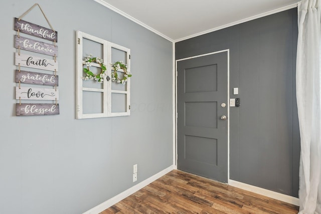 foyer featuring dark wood finished floors, baseboards, and ornamental molding