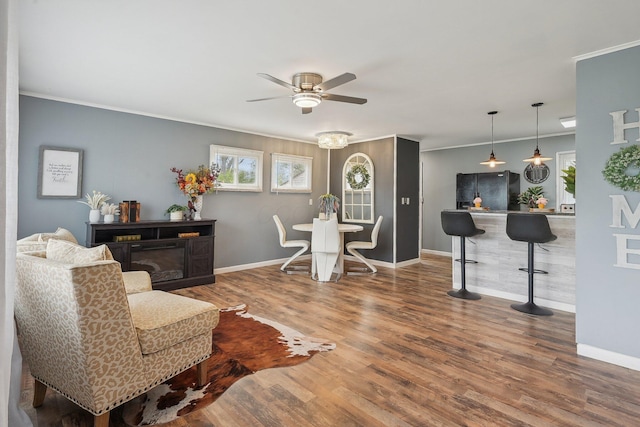 sitting room featuring wood finished floors, baseboards, and ceiling fan