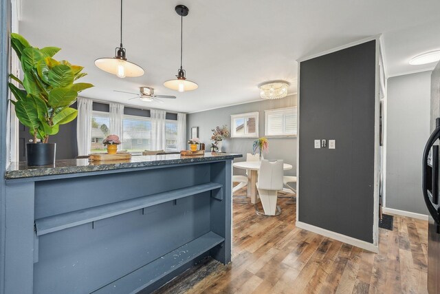 bar with decorative light fixtures, wood finished floors, a ceiling fan, and baseboards