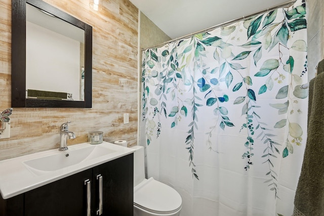 full bathroom with toilet, a shower with curtain, vanity, and wooden walls