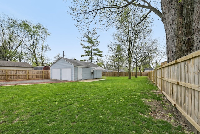 view of yard with a fenced backyard, an outdoor structure, and a detached garage
