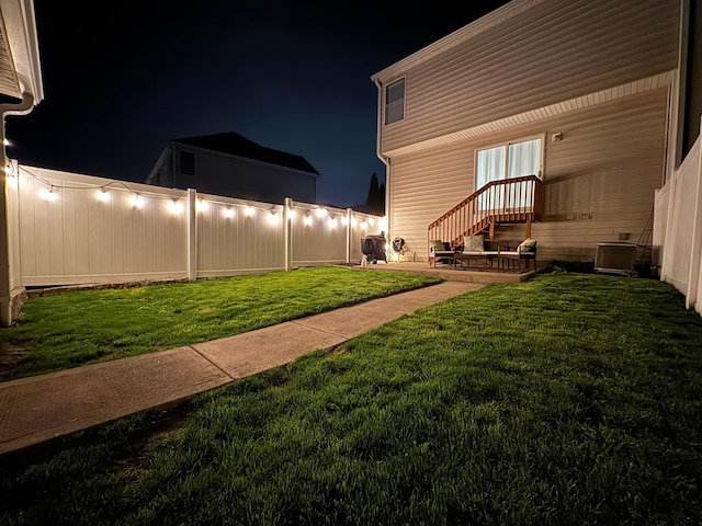 yard at twilight featuring a patio area, central AC unit, and fence