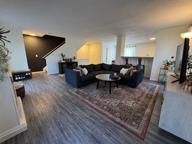 living room with baseboards, stairway, and wood finished floors