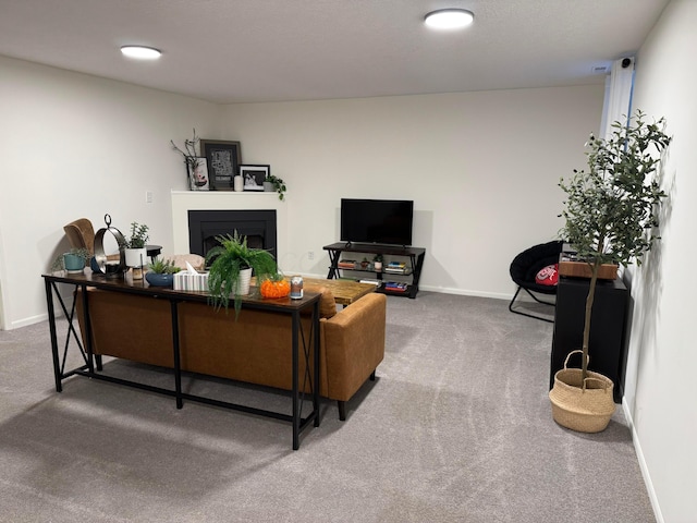 living room featuring a fireplace, carpet flooring, and baseboards