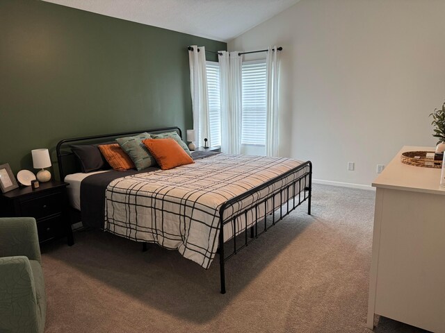 carpeted bedroom with baseboards and lofted ceiling