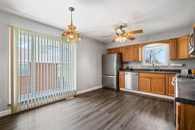 2852 Longfield Rd, Columbus, OH 43204 - kitchen featuring appliances with stainless steel finishes, dark countertops, dark wood-style flooring, and a ceiling fan