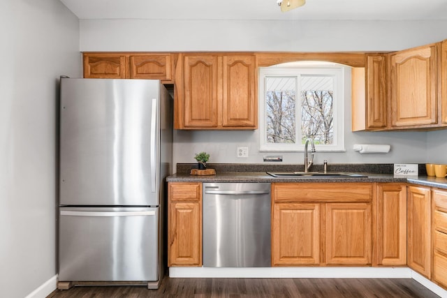 2852 Longfield Rd, Columbus, OH 43204 - kitchen featuring appliances with stainless steel finishes, a sink, dark countertops, and dark wood finished floors