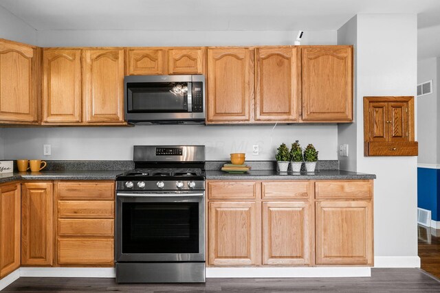 2852 Longfield Rd, Columbus, OH 43204 - kitchen with appliances with stainless steel finishes, dark countertops, and dark wood-type flooring