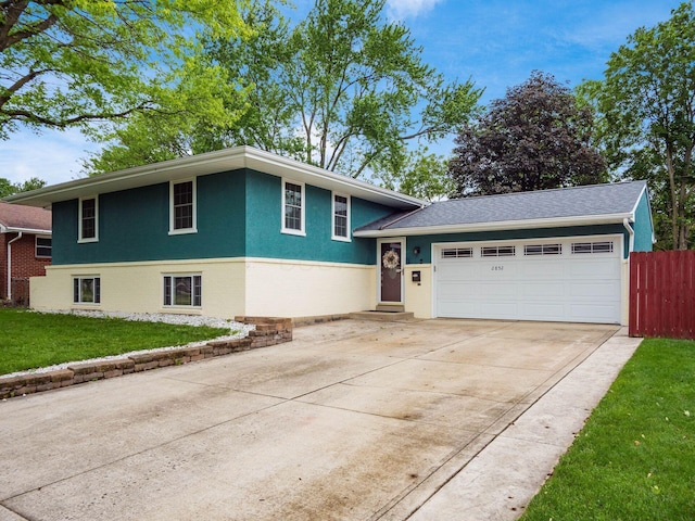 2852 Longfield Rd, Columbus, OH 43204 - split level home featuring concrete driveway, a garage, and stucco siding