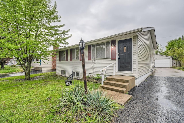 view of front of property featuring entry steps, an outdoor structure, and a garage
