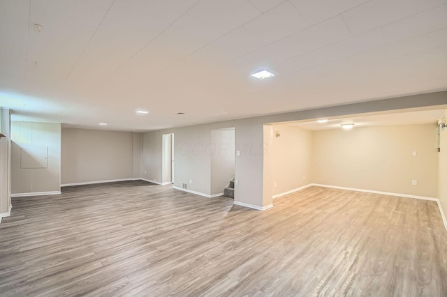 finished below grade area featuring wood finished floors, stairs, and baseboards