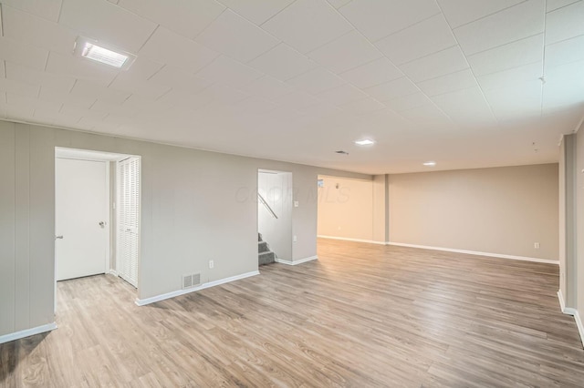 finished below grade area with light wood-style floors, baseboards, stairway, and recessed lighting