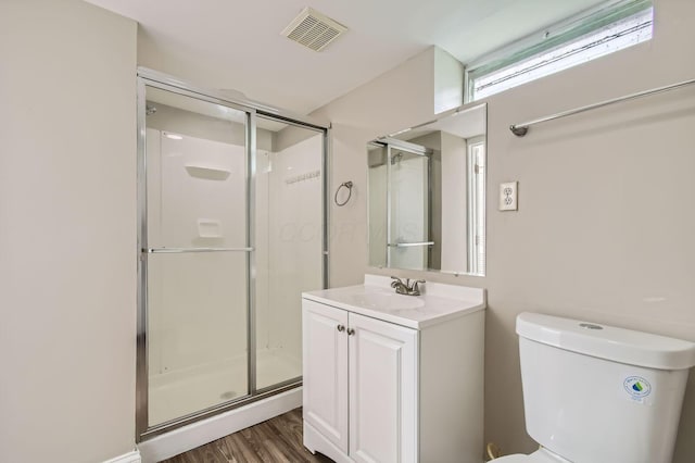 full bathroom featuring a stall shower, wood finished floors, vanity, and toilet