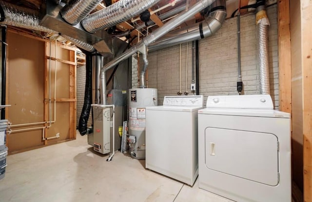 clothes washing area featuring water heater, independent washer and dryer, heating unit, and laundry area