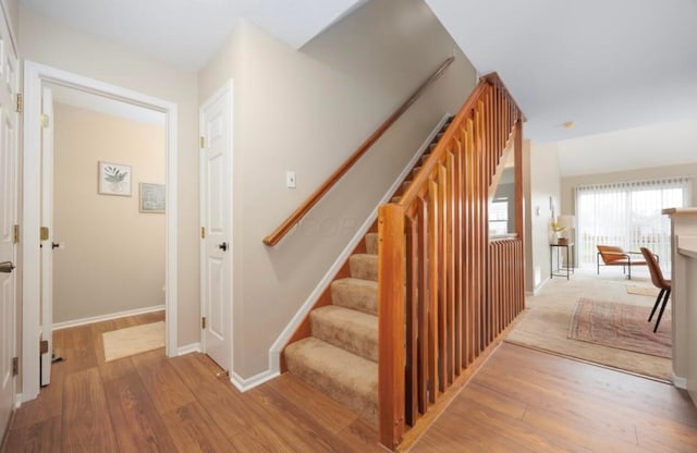 stairway with wood finished floors and baseboards