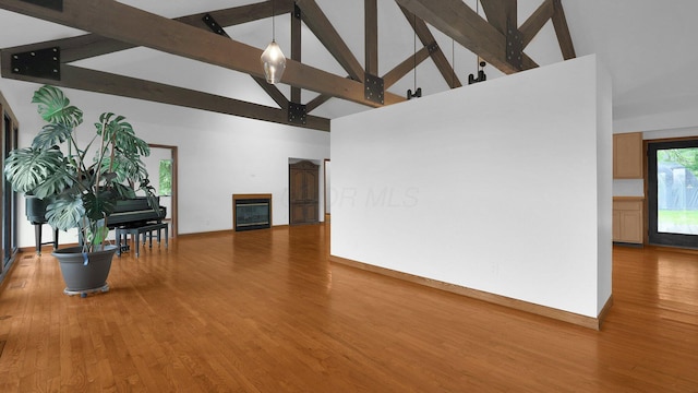 3448 Ostrander Rd, Ostrander, OH 43061 - living area featuring high vaulted ceiling, wood finished floors, beamed ceiling, a glass covered fireplace, and baseboards