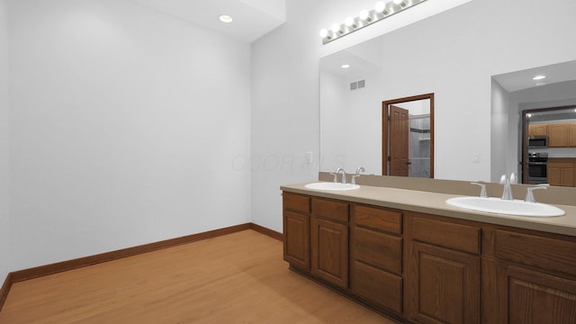 3448 Ostrander Rd, Ostrander, OH 43061 - full bathroom with wood finished floors, double vanity, recessed lighting, and baseboards