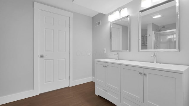 3448 Ostrander Rd, Ostrander, OH 43061 - bathroom featuring wood finished floors, double vanity, baseboards, and a shower