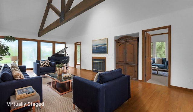 3448 Ostrander Rd, Ostrander, OH 43061 - living room featuring high vaulted ceiling, a glass covered fireplace, light wood finished floors, beamed ceiling, and baseboards