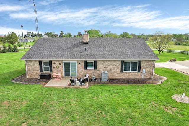 back of house featuring fence, roof with shingles, a chimney, a patio, and a yard