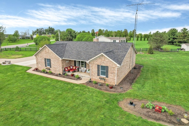 view of front of house with roof with shingles, fence, a front lawn, and brick siding