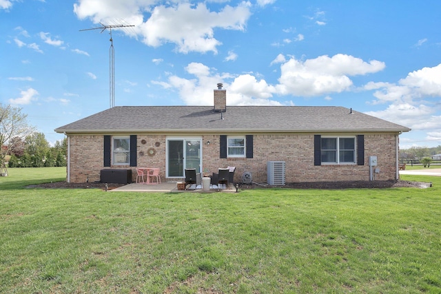 rear view of house featuring a lawn, a patio area, central AC, and a chimney