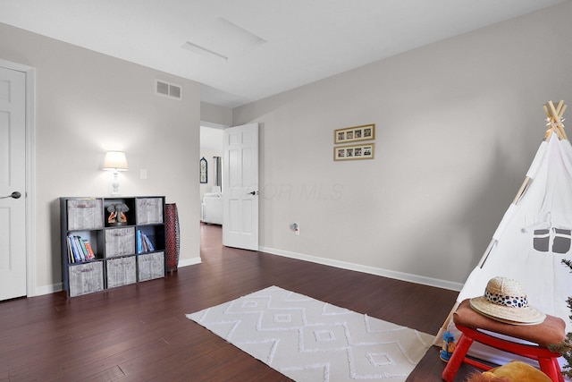 playroom with visible vents, attic access, baseboards, and wood finished floors