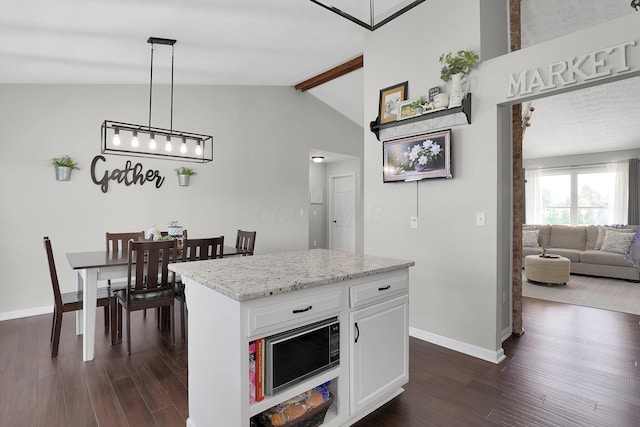 kitchen with dark wood-style flooring, built in microwave, baseboards, white cabinets, and vaulted ceiling with beams