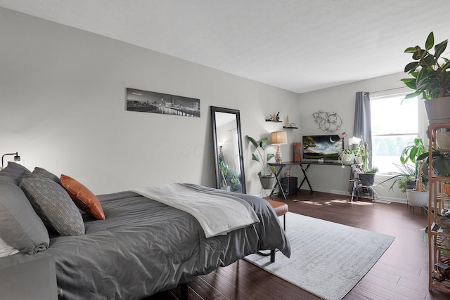 bedroom with baseboards and wood finished floors