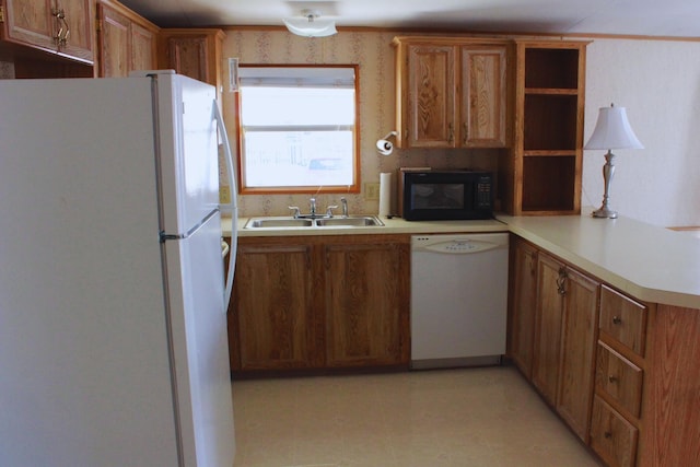 45 Ravine Ridge Dr, Delaware, OH 43015 - kitchen with white appliances, a peninsula, light countertops, brown cabinets, and a sink